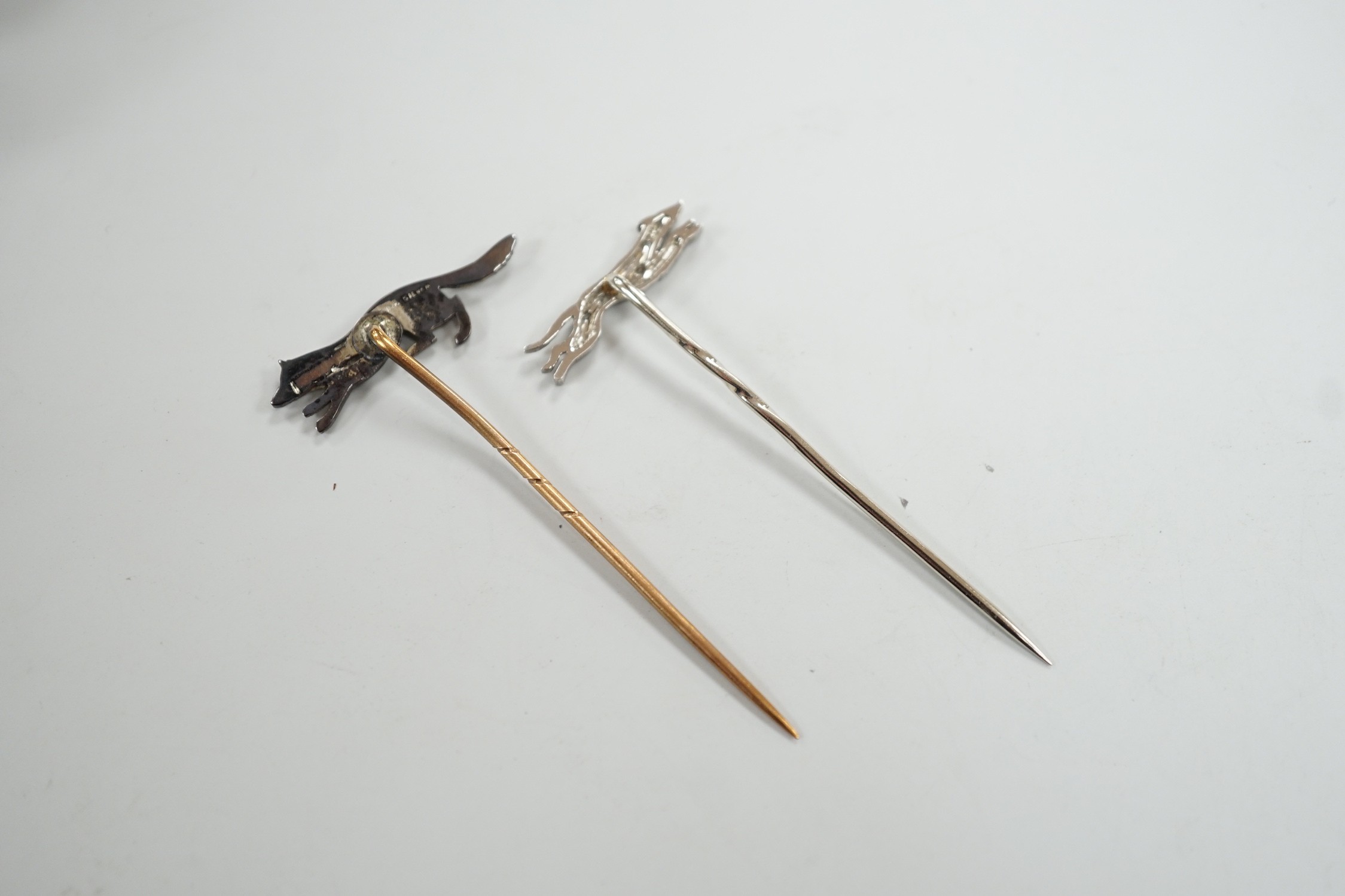 A mid 20th century white metal and diamond chip set hound stick pin, 57mm, in Asprey box and a similar paste set fox stick pin.